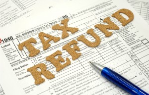 Corkboard letters spelling out "Tax Refund" on top of an IRS form 1099